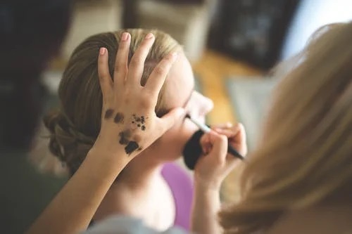 A woman doing makeup on another woman